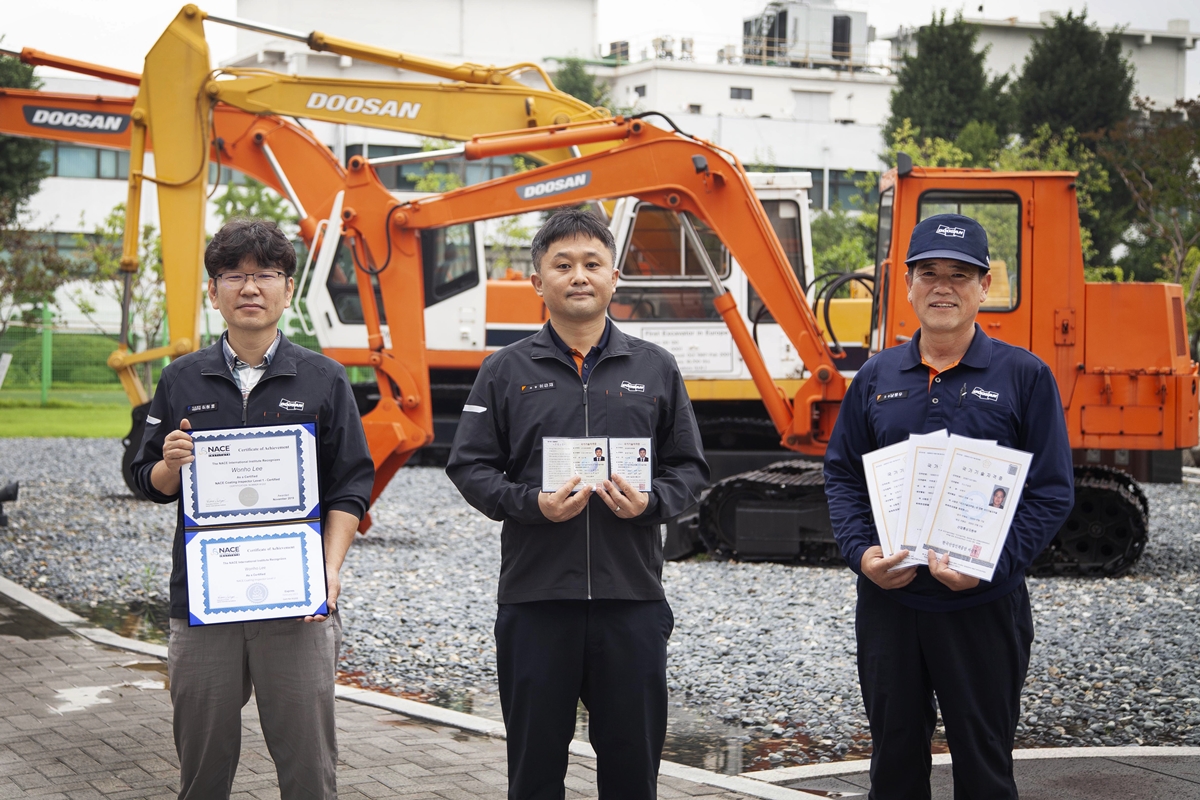 Doosan Infracore continues to boost its technical competitiveness by helping its employees acquire certifications as master craftsmen, professional engineers, and international coating inspectors: (from left) Wonho Lee, an international coating inspector, Geunjae Lee, a professional engineer in two fields, and Byeongwoo Nam, a master craftsman in three fields.